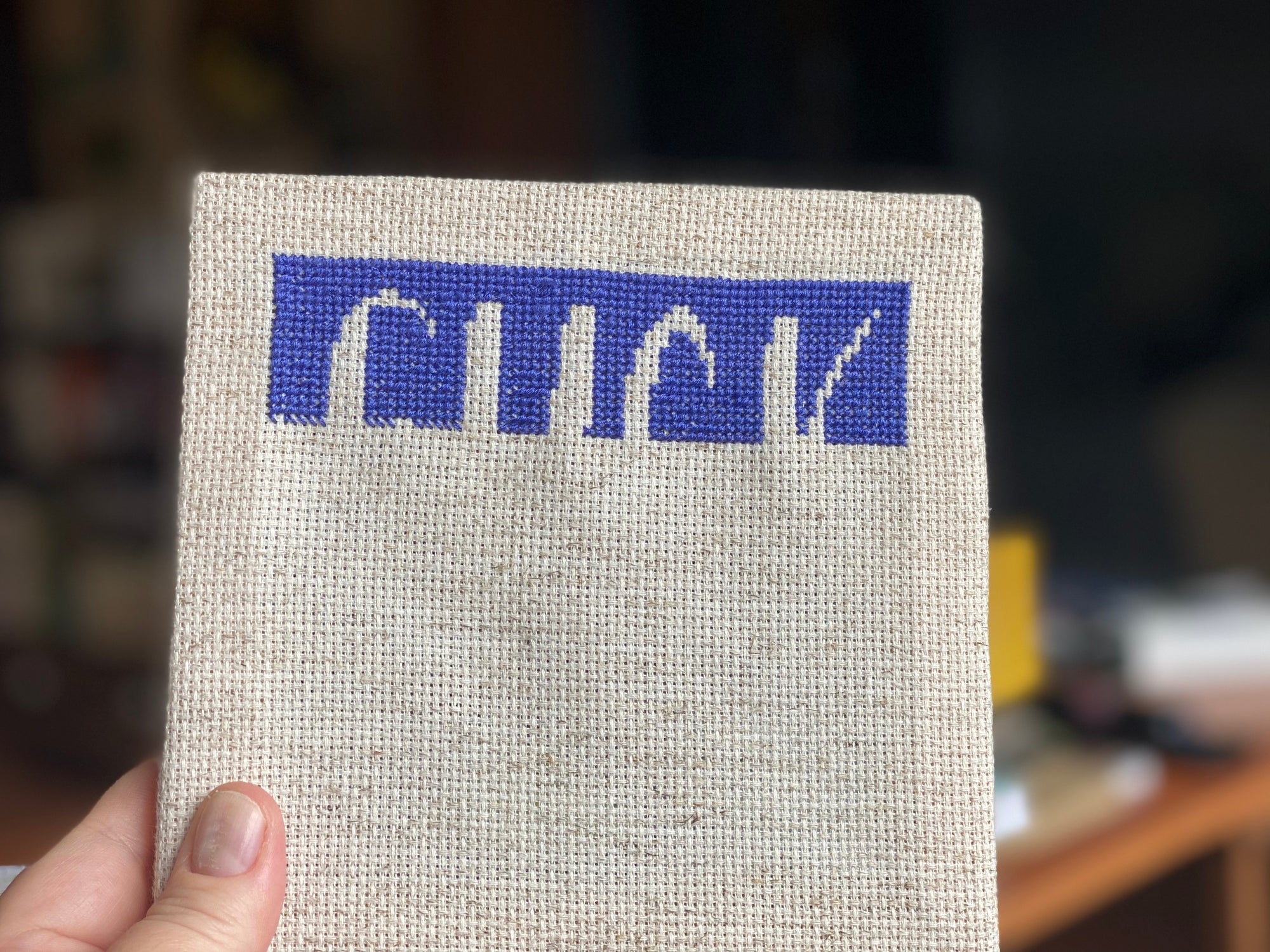 Partially completed cross stitch kit that will says "Fuck This" Stitched in dark purple on an off-white canvas. 