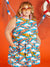 A woman with feathered hair stands in front of an orange background. There is a life preserver and buoys hanging in the background along with a net. She is wearing square sun glasses and a dress covered in a lobster print. The dress has pockets - which she demonstrates by putting her hands in them. 