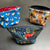 Three examples of zippered box bottom bags. On the left, chickens and roosters on a blue background and lined with red polka dot fabric & a red zipper. On the right, a Star Wars graphic lined with black fabric. In the center front, a woodland theme with pretty green foliage and a red fox. 