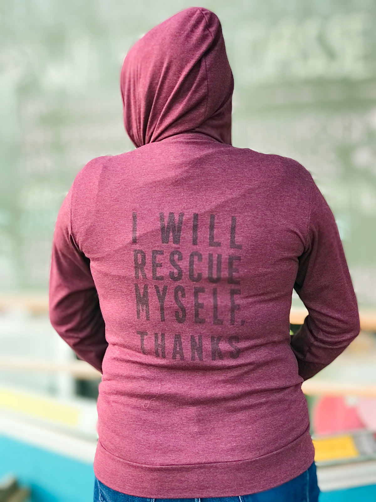 Heather maroon tri-blend hooded unisex sweatshirt. On the back, the phrase, &quot;I Will Rescue Myself, Thanks&quot; is screenprinted in a darker maroon ink. 