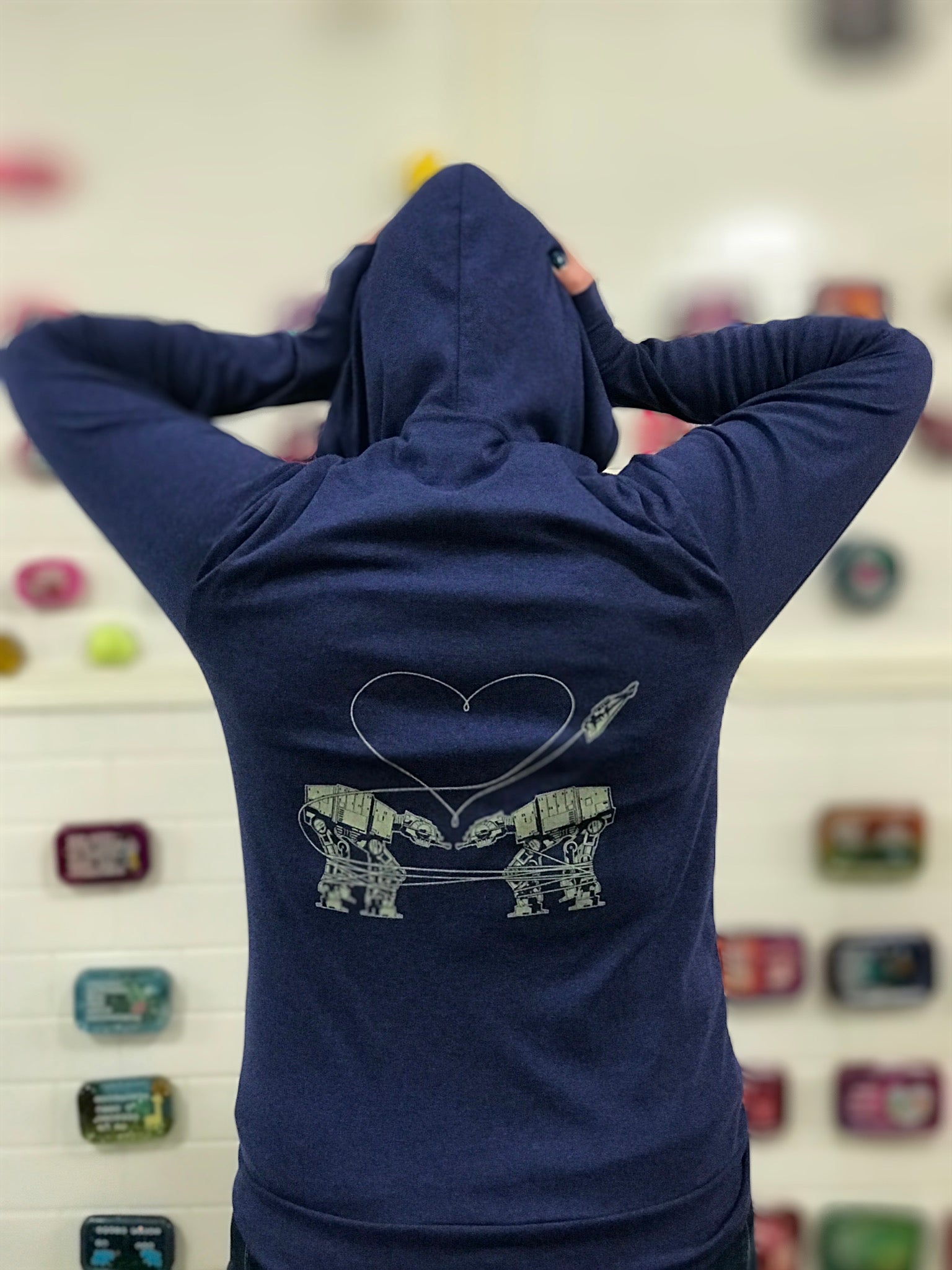 Heathered royal blue triblend unisex hooded sweatshirt. Two AT-AT's are shown falling in love. 